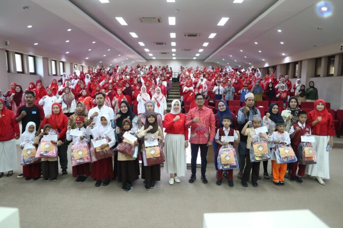 PJ Sekda Kota Makassar, Firman Hamid Pagarra, bersama Pj Ketua DWP Makassar, Lia Firman, menyerahkan bantuan pendidikan kepada 15 anak satgas kebersihan di Ruang Sipakatau pada 23 Agustus 2024.