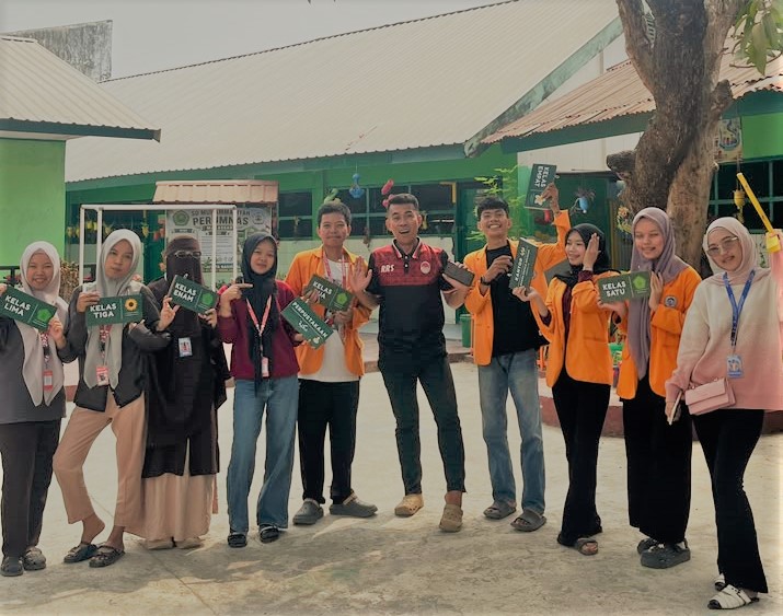 Mahasiswa AMSD PGSD FIP UNM membuat papan nama kelas di SD Muhammadiyah Perumnas sebagai bentuk pengabdian untuk mendukung penataan sekolah, kenyamanan belajar, dan persiapan menuju Sekolah Adiwiyata Nasional.